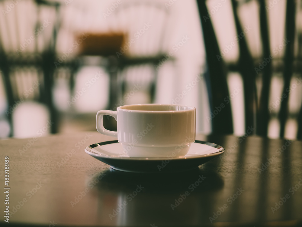 Hot coffee in white cup served in a very quiet cafe. Hot coffee in white cup served in a very quiet cafe.