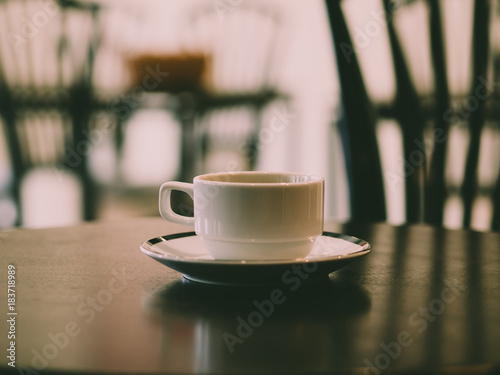 Hot coffee in white cup served in a very quiet cafe.