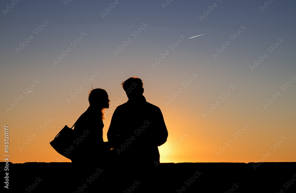 Silhouette of unknown romantic couple watching sunset from Saint Jorge Castle. Lisbon, Portugal