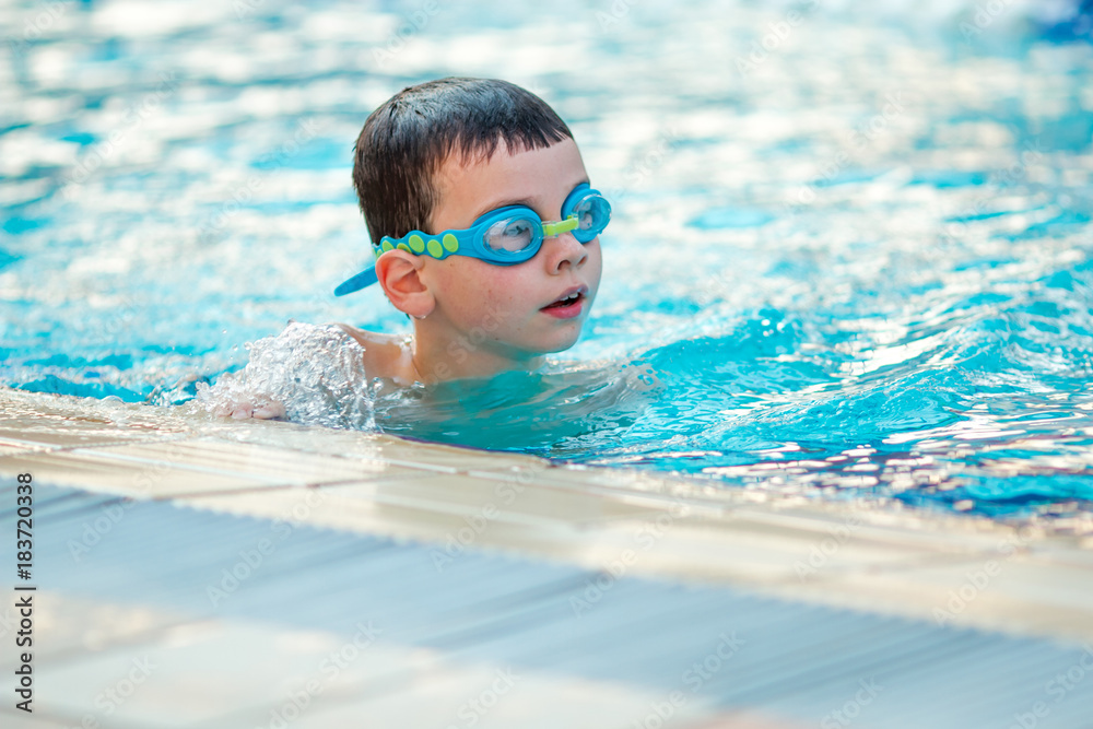 Close up of child boy swimming in pool.
