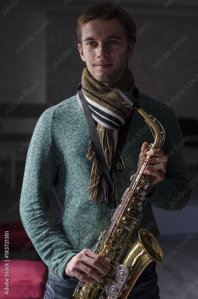 Naklejka premium guy with a saxophone in his hands