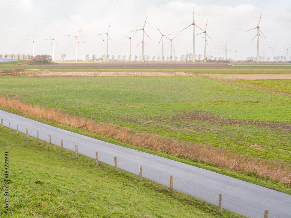 Schmale Straße entlang einer Windfarm Hintergrund Schmale Straße entlang einer Windfarm Hintergrund