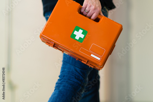 Obraz na plátne Man with first aid kit runs to help