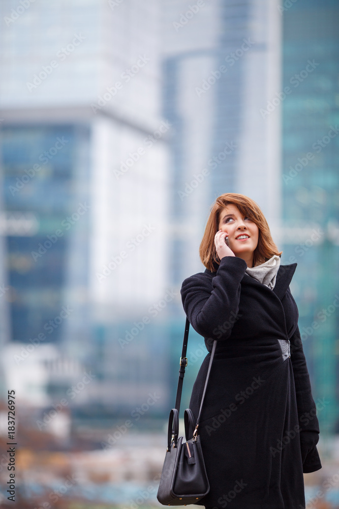 Photo of girl in black coat talking on phone