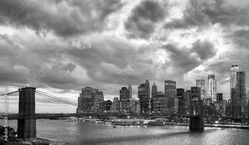 Black and white picture of Manhattan and Brooklyn Bridge with dramatic cloudscape at dusk  New York  USA.
