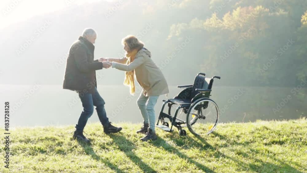 Senior couple with wheelchair in autumn nature. Senior couple with wheelchair in autumn nature.