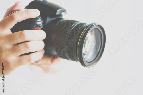 Girl hands holding photo camera with vintage color effect, white background, copy space