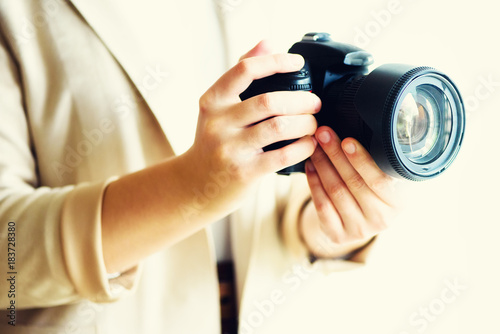 Girl hands holding photo camera, white background, copy space. Travel and shoot concept