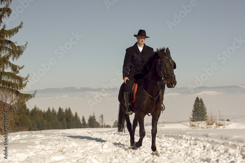 young man riding horse outdoor in winter