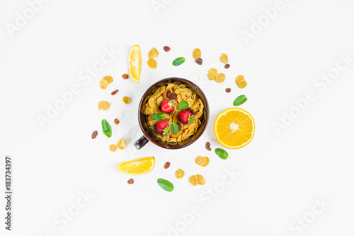 Cereal, morning breakfast, corn flakes, raisins, almonds, mint leaves, orange juice, strawberry, top view, white background, flat lay. The concept of healthy, proper nutrition, ditox.