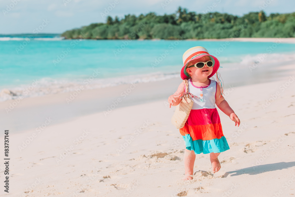 happy cute little girl walk on sand beach