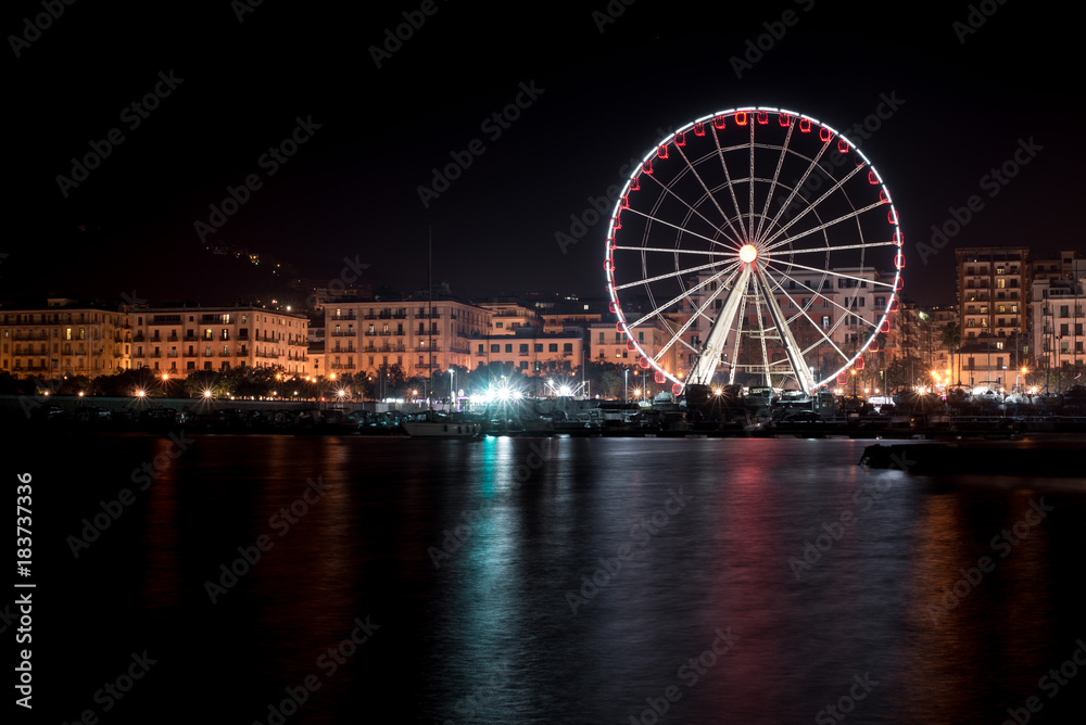 Night view of the ferris wheel on the seaside in Salerno, Italy