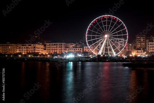 Night view of the ferris wheel on the seaside in Salerno, Italy