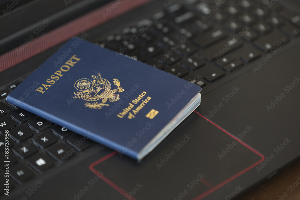American Passport On Laptop Keyboard American Passport On Laptop Keyboard