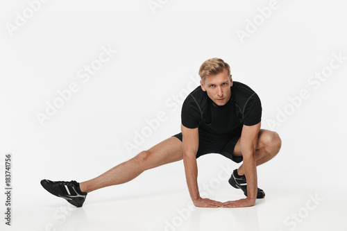Confident sportsman flexing on white