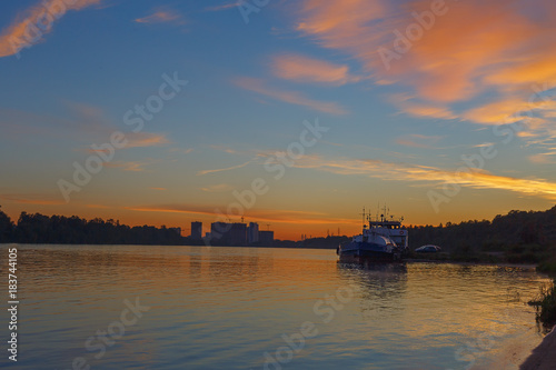 the silhouettes of the ship and the city on the background of beautiful sunset