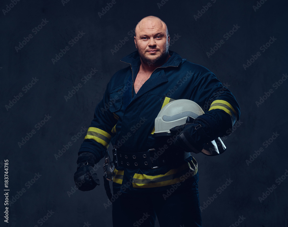 Firefighter in uniform over dark grey background. Firefighter in uniform over dark grey background.