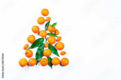 Christmas tree made from fresh mandarin with leaves on a white background. Ripe delicious fruit. Symbol of the New Year and Christmas