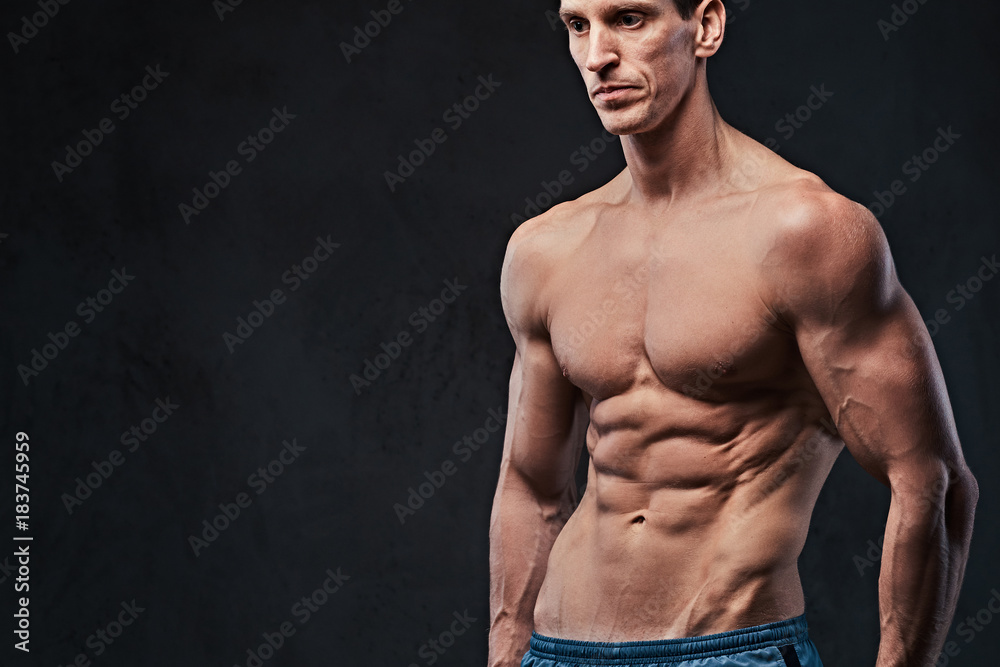 Fototapeta premium Shirtless muscular male over dark background.