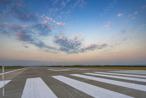 Runway, airstrip in the airport terminal with marking on blue sky with clouds background. Travel aviation concept. photo