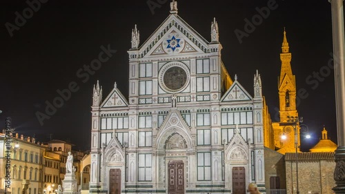 Tourists on Piazza di Santa Croce at night timelapse with Basilica di Santa Croce Basilica of the Holy Cross in Florence city. photo