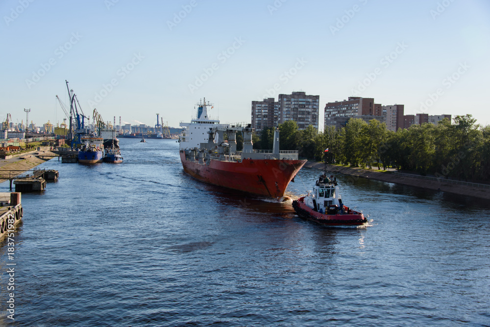 Fototapeta premium Towing of cargo vessel in port