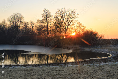 Sunrise at the frozen lake during winter © Piotr Jankowiak