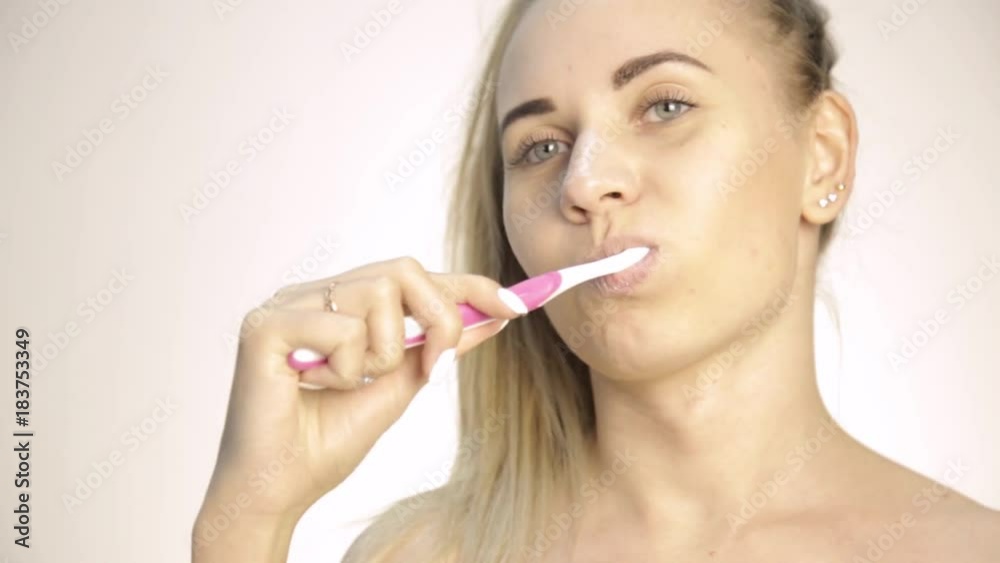 Young beautiful woman brushing her teeth Young beautiful woman brushing her teeth