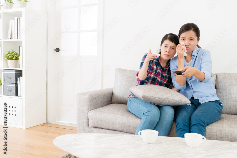 beautiful pretty sisters sitting on sofa couch