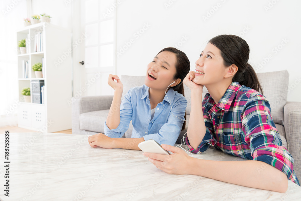 leisurely women friends relaxing in living room leisurely women friends relaxing in living room