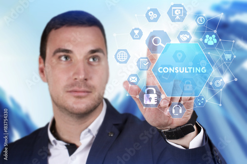 Business, Technology, Internet and network concept. Young businessman working on a virtual screen of the future and sees the inscription: Consulting