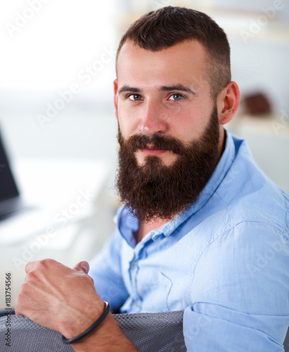 Young businessman sitting on chair in office