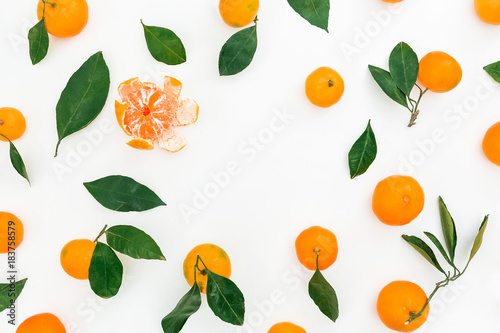 Round frame of citrus and leaves on white background. Flat lay. Top view