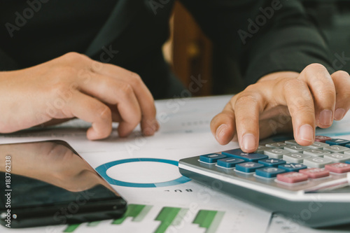 Close up hand of businesswoman accountant or banker using calculator, business finance calculation concept