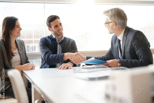 Young couple meeting financial advisor for home investment