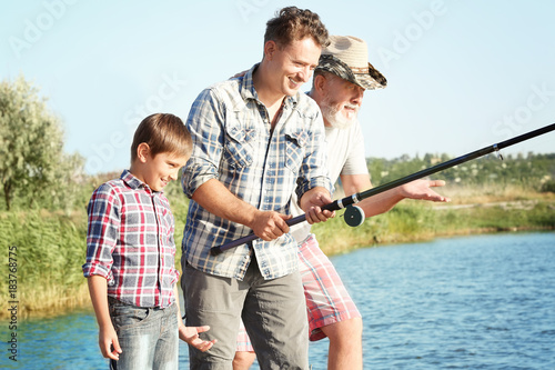Family fishing on pond toge...