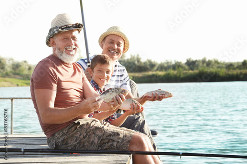 Family fishing on pond toge...