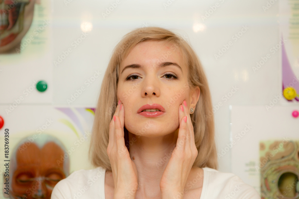 facial gymnastics. the girl does massage and rejuvenating exercises for the face facial gymnastics. the girl does massage and rejuvenating exercises for the face