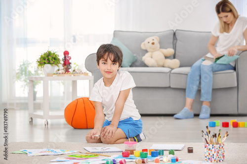 Little boy painting while s...