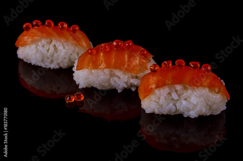 Sushi delicious with salmon three pieces black background