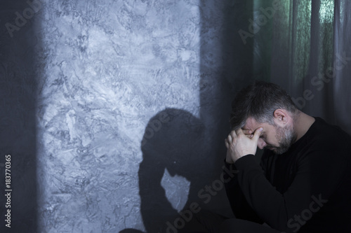 Middle-aged depressed man holding head