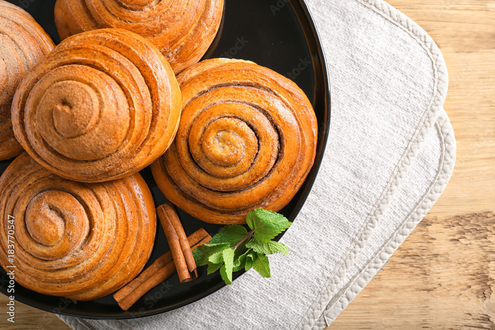 Plate with sweet cinnamon rolls on table Plate with sweet cinnamon rolls on table