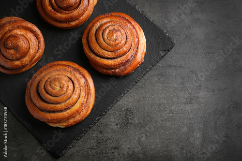 Slate plate with sweet cinnamon rolls on table