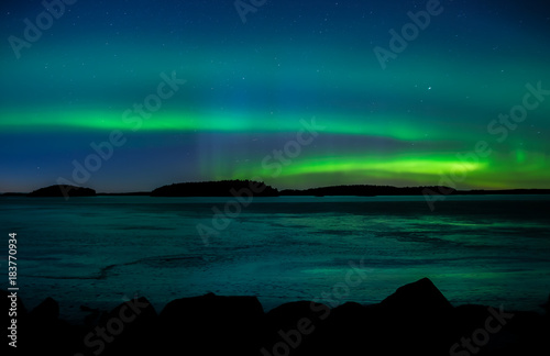 Northern lights dancing over frozen lake in Farnebofjarden national park in Sweden. © Conny Sjostrom