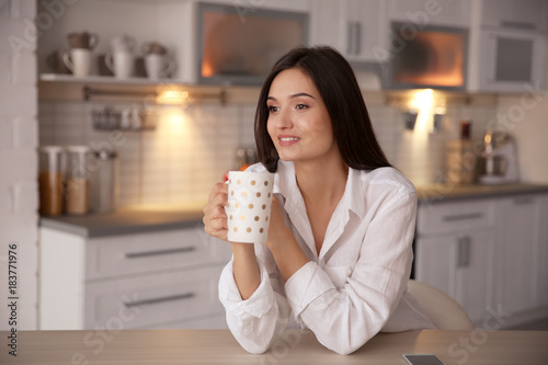 Young woman drinking tea in...