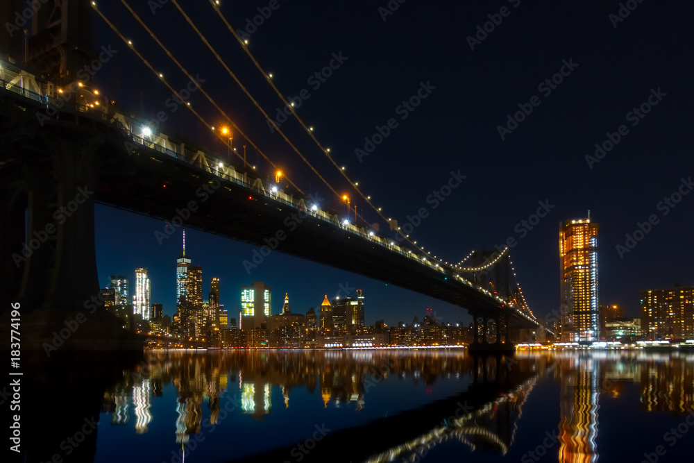 New York City Panoramic landscape view of Manhattan with famous Brooklyn Bridge by night.