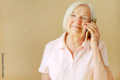Portrait of beautiful smiling senior woman with the smartphone.