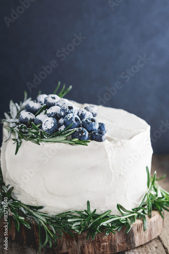 The white cream cake with fresh blueberries decorated fresh rosemary.