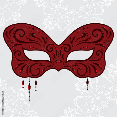 Red masquerade mask in the shape of a butterfly with pendants