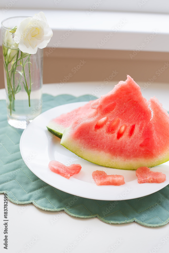 on the table is a piece of watermelon on a white plate